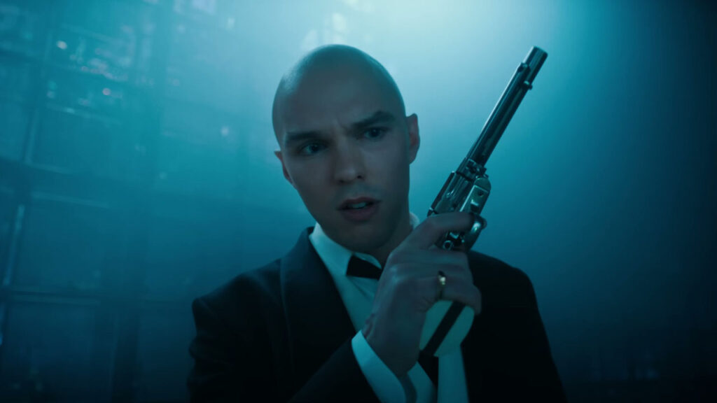 Lex Luthor, holding a gun, played by Nicholas Hoult.