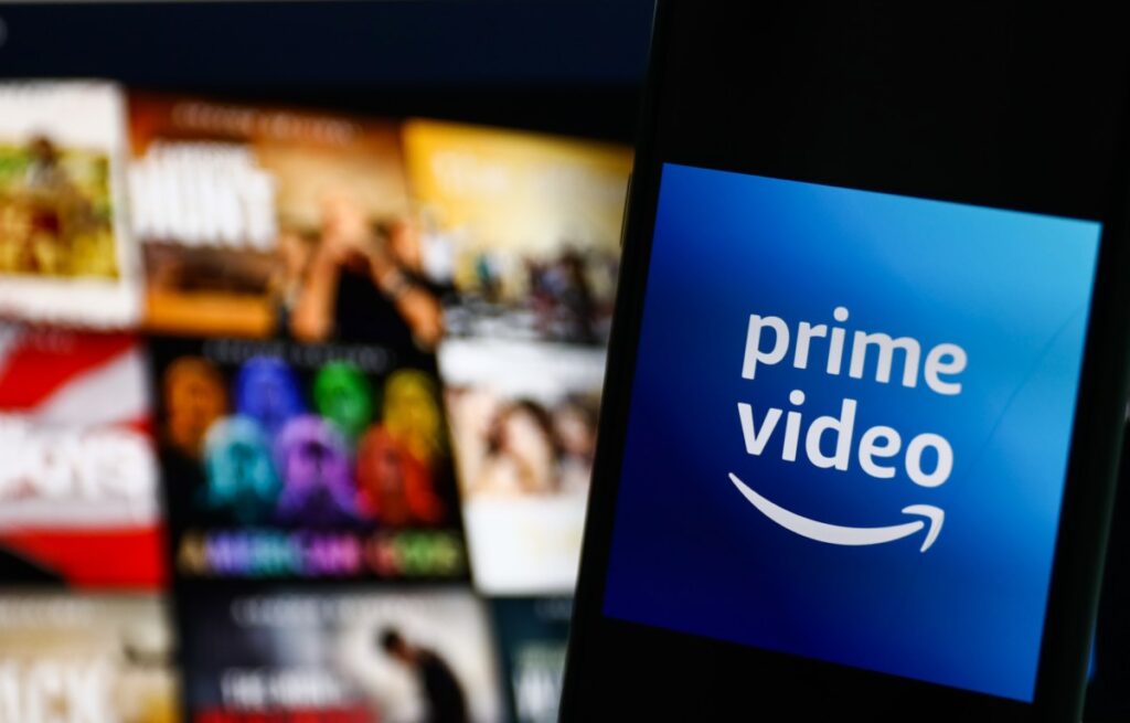 The logo of Amazon Prime Video against a blurred backdrop of tiles on a television screen.