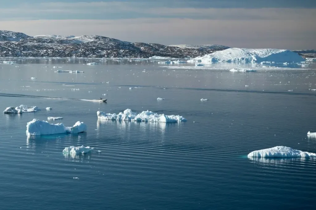 Mila partners with PolArctic to measure sea ice in the High Arctic Pieces of ice float in a blue sea.