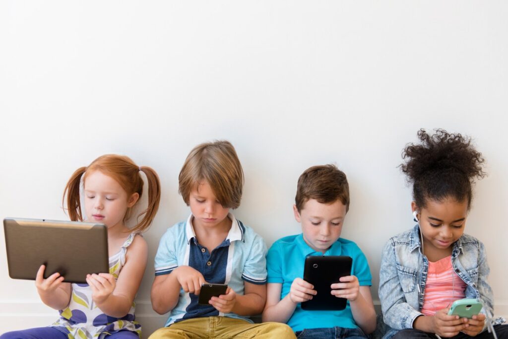 Parents want safer phones for kids. These companies are answering the call. Image of four children using tablets and smartphones.
