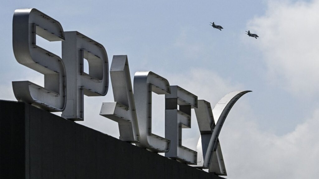 SpaceX has an AI device prototype, and it sure sounds phone-ish US billionaire businessman and pilot Jared Isaacman flies in formation aboard a fighter jet over the SpaceX sign, close to the Starship spacecraft, before his third test flight from Starbase in Boca Chica, Texas, on March 13, 2024.
